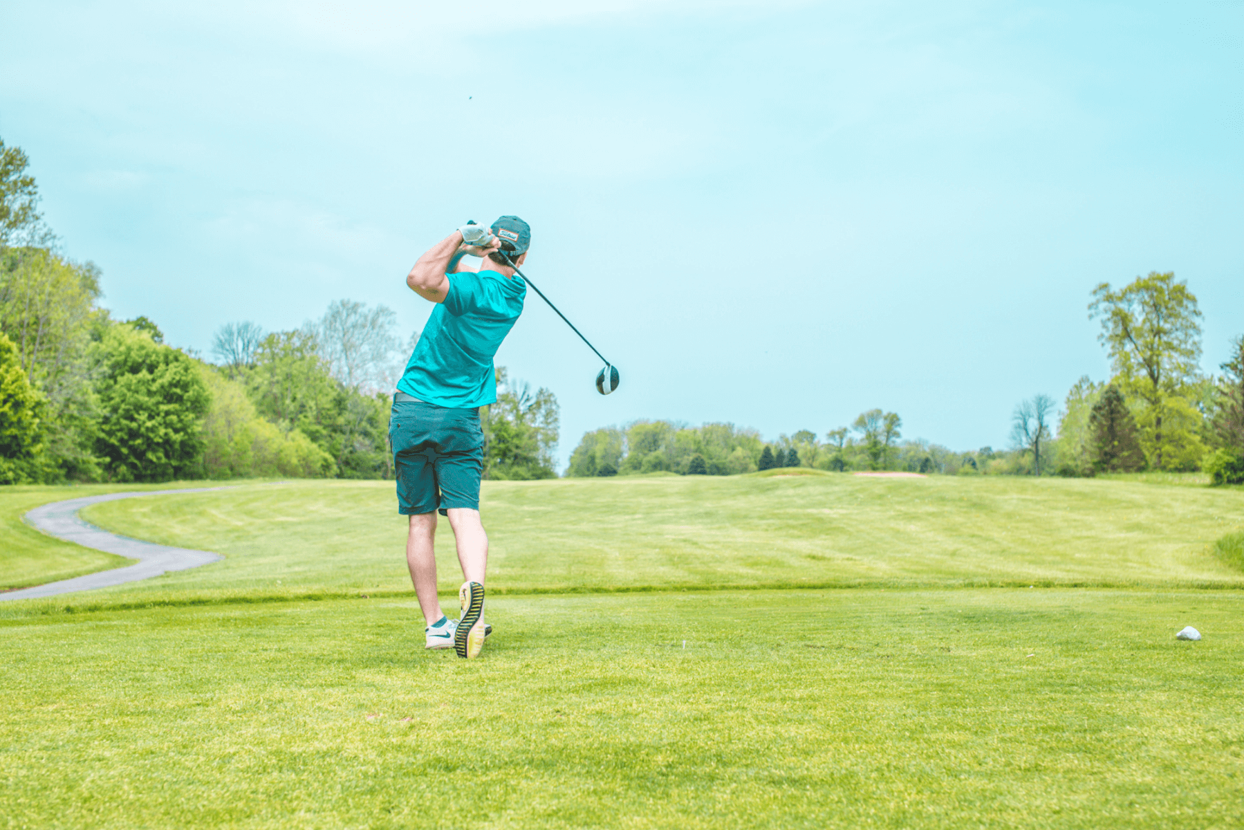 man playing golf under blue sky during daytime